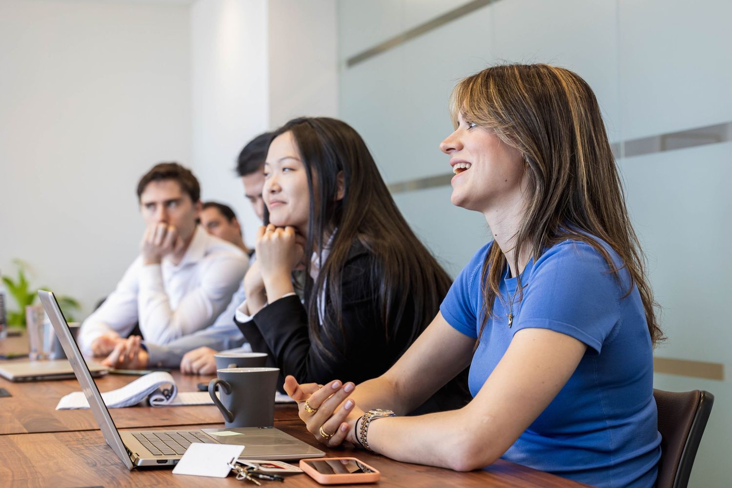 Business professionals working together at conference table in modern office setting.