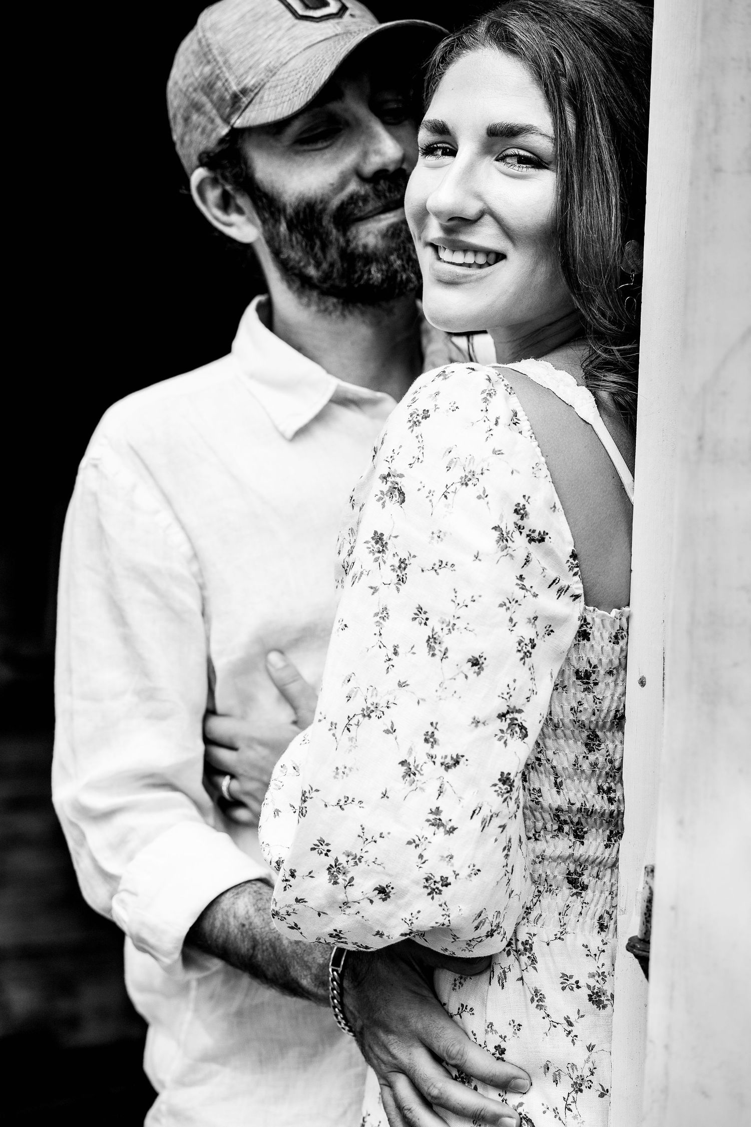 artistic black and white portrait of young woman looking over shoulder with partner looking at her