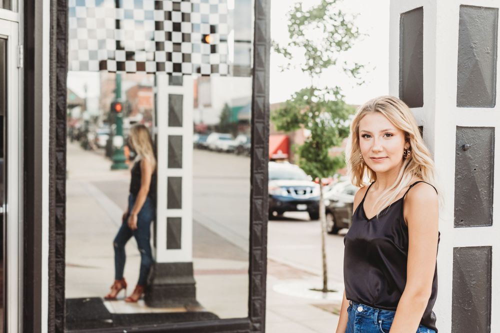 Urban portrait with checkered wall and street elements in background.
