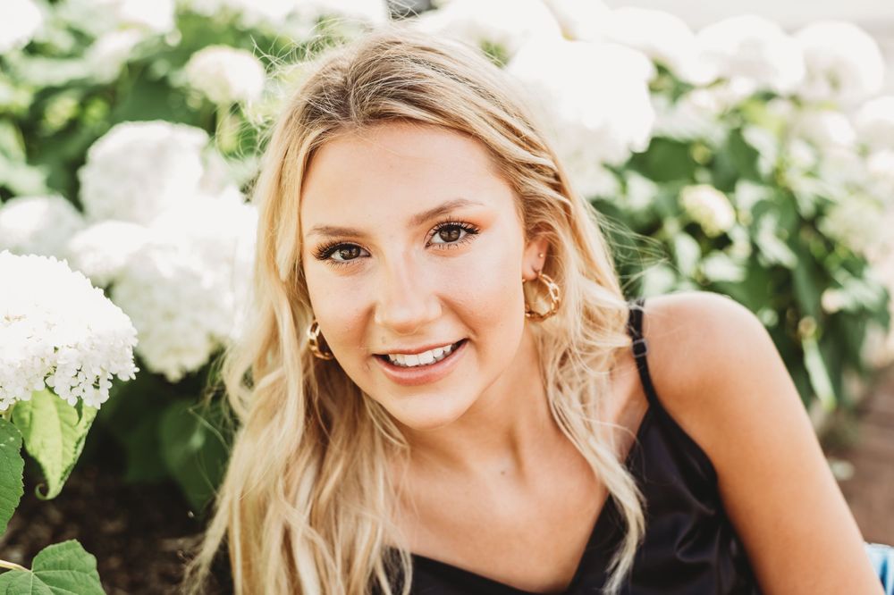 Casual outdoor portrait with lush garden background.