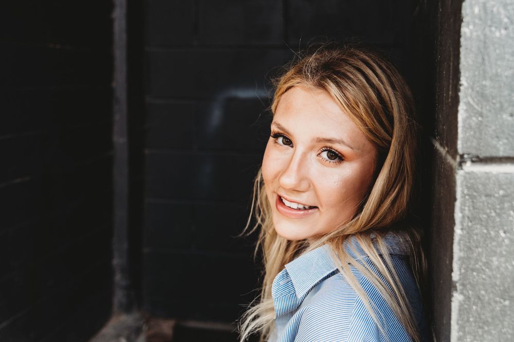 Urban fashion photography in industrial setting with moody lighting.