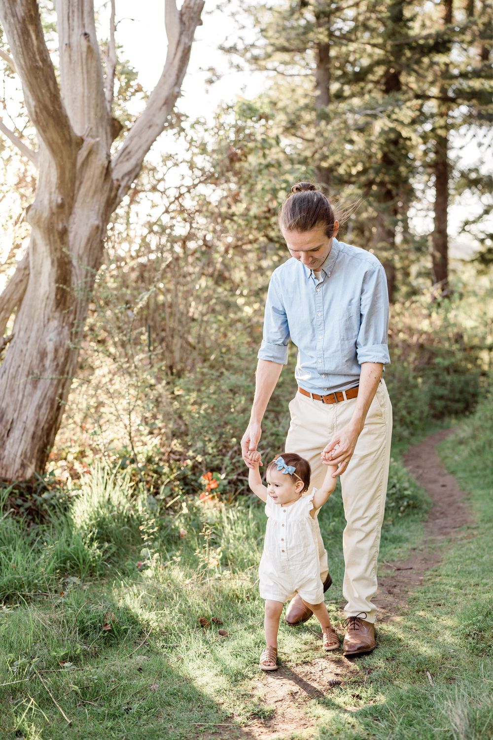 father helps daughter walk milestone photographer one year lifestyle photoshoot bellingham