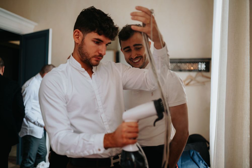 Two people in white shirts sit together reviewing documents in a casual indoor setting.