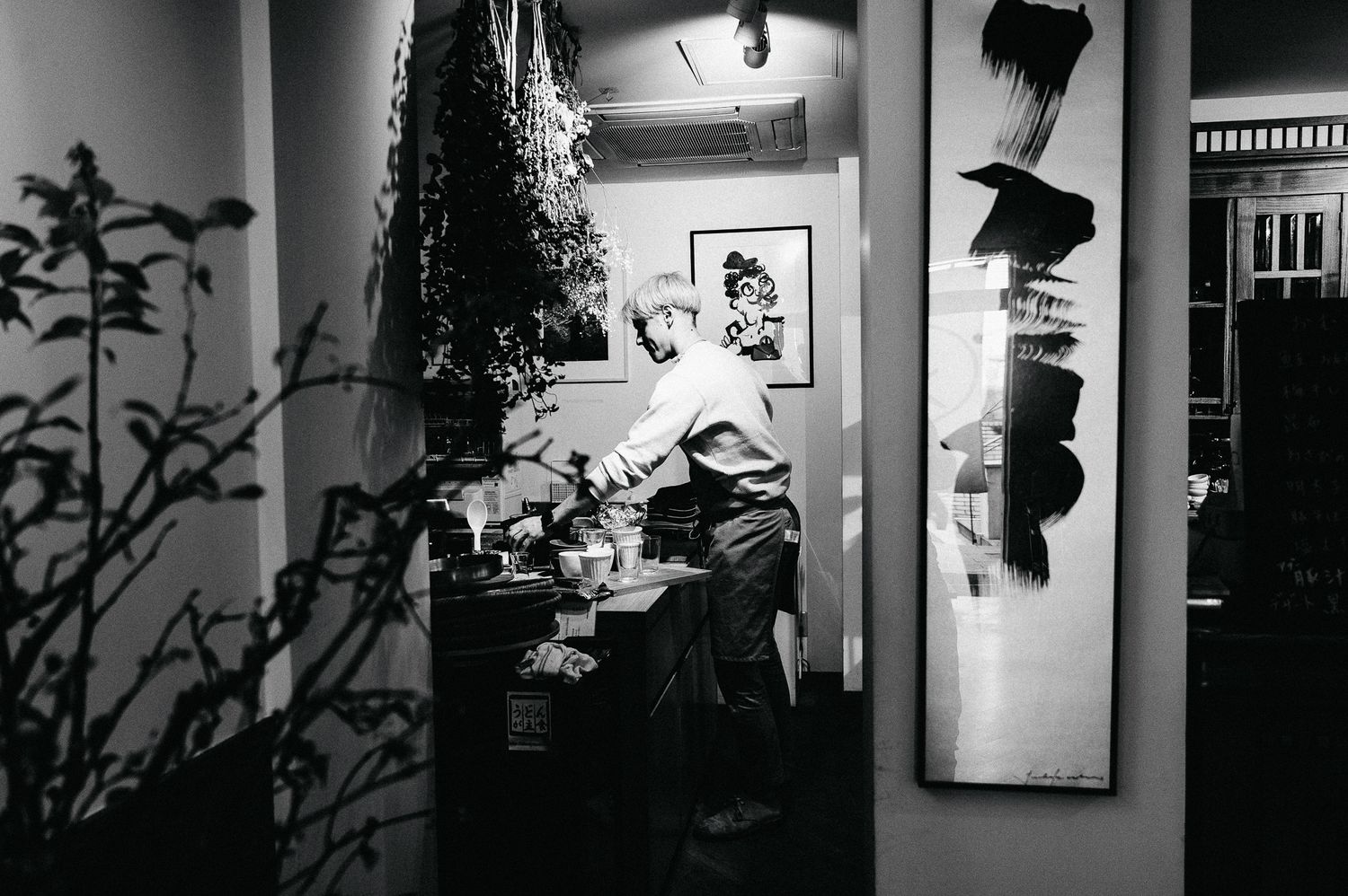 Dark corridor interior with decorative elements and wall hangings in black and white.