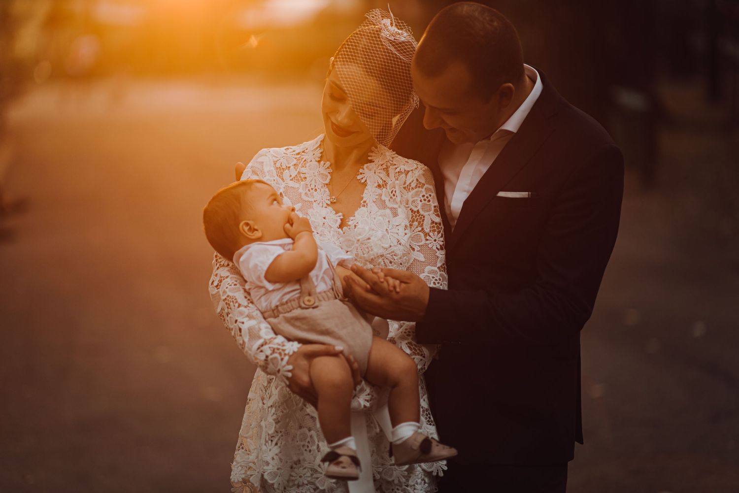 A couple embraces with their baby during golden hour photography session.