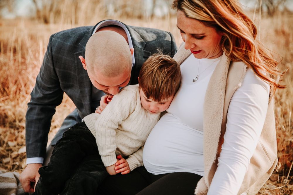 A family snuggles together candidly in a Denver park