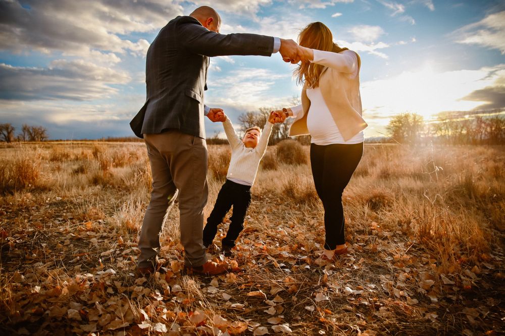 A family dances together in a golden field