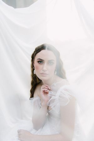 Ethereal bridal portrait showing her Elli Nicole Bridal dress and pearl jewellery.