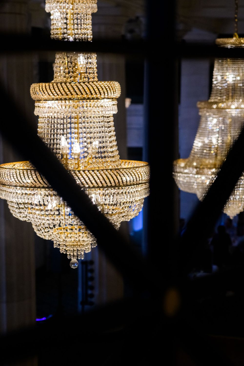 Detailed view of vintage crystal chandeliers with decorative gold-trimmed tiers.