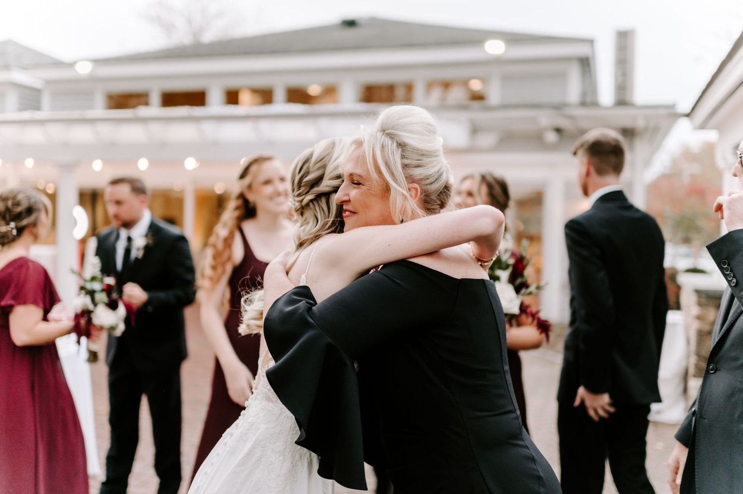 Wedding party members sharing emotional moments during outdoor celebration.
