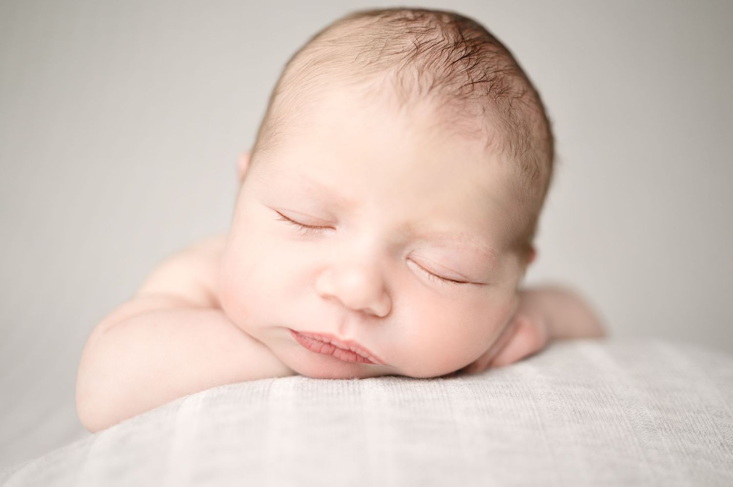 Serene newborn portrait session with soft natural lighting.