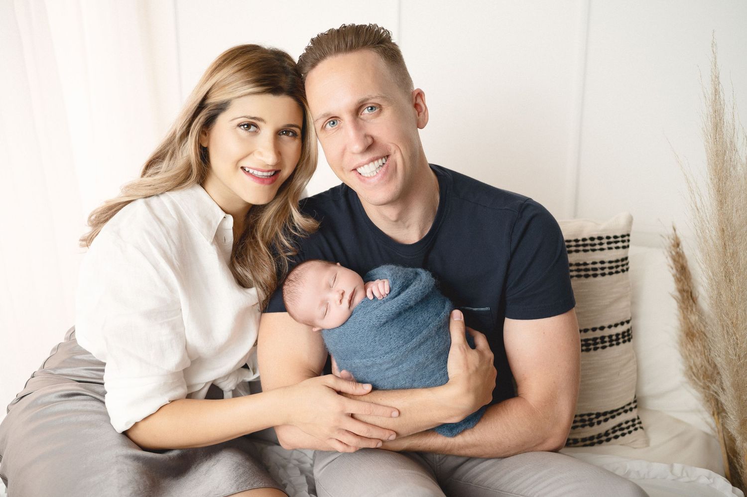 Modern family portrait session with natural poses on cream background.