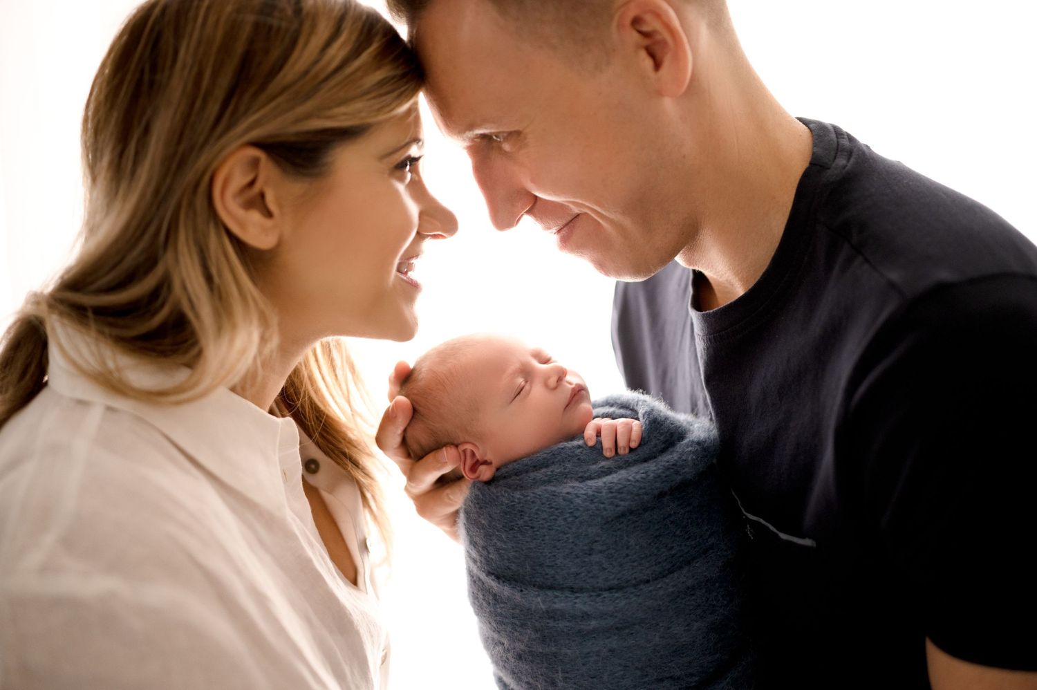 Intimate family portrait series with loving expressions in bright studio setting.