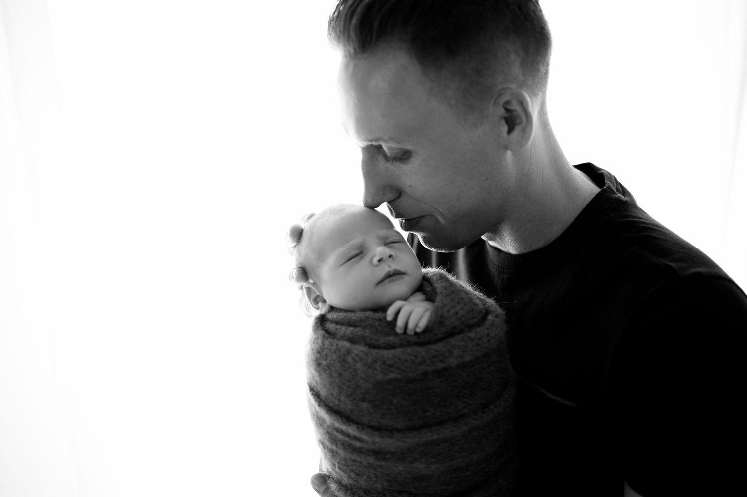 Black and white newborn photo series showing soft, dreamy close-up portraits.
