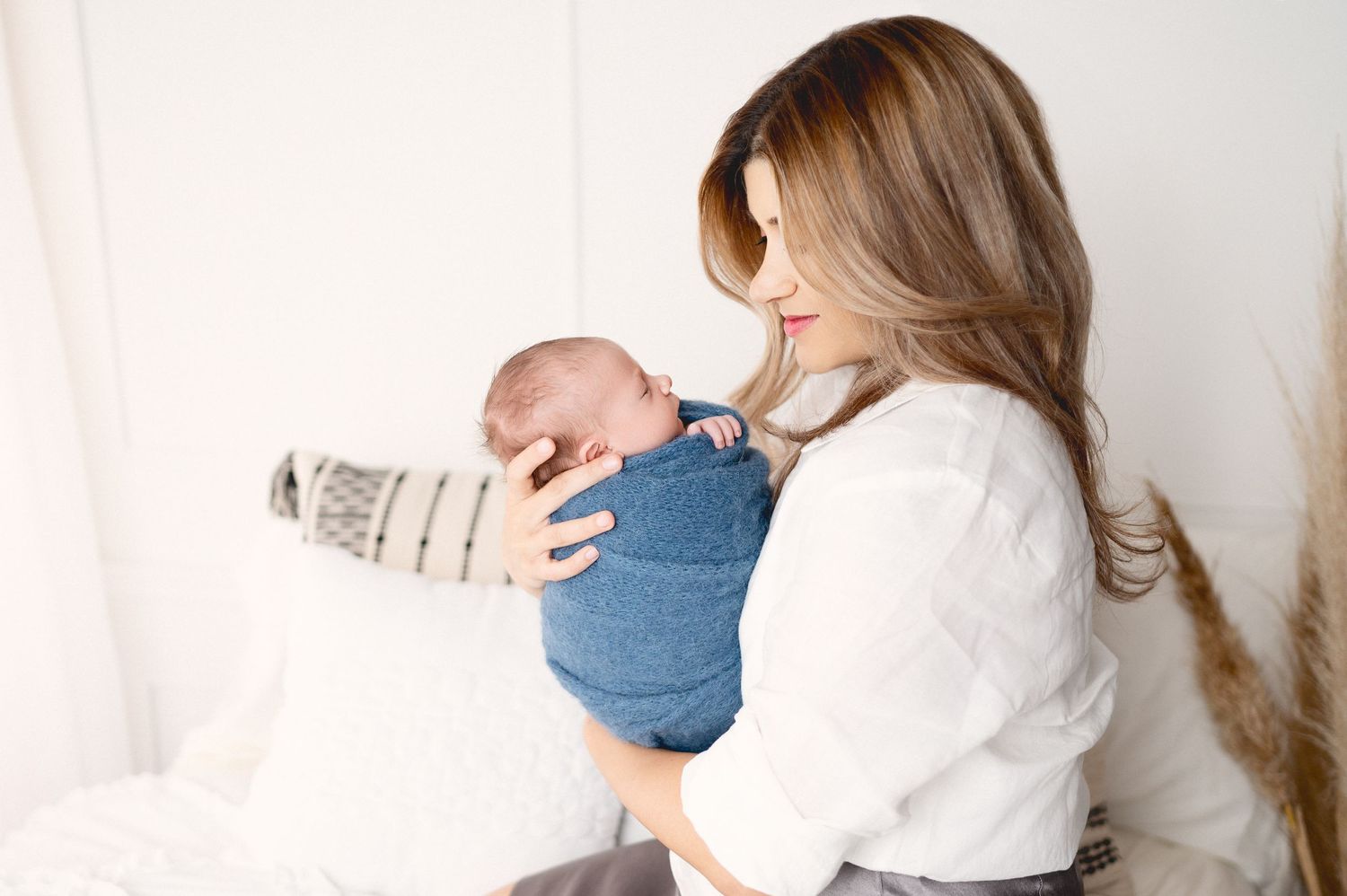 Modern family portrait series in bright studio setting with white and blue color scheme.