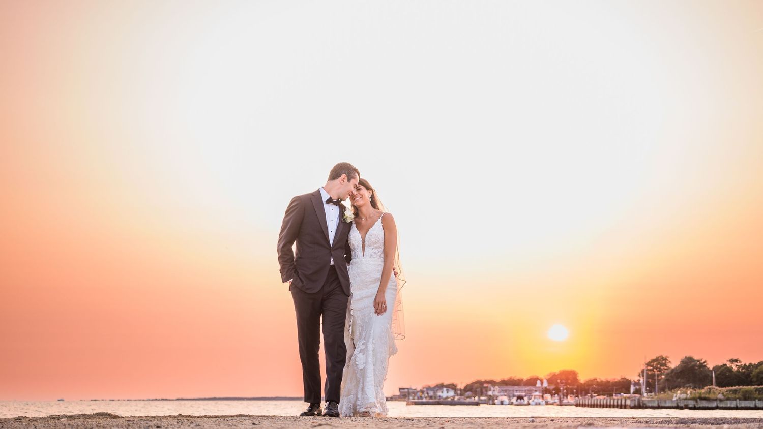 Lovely couple happily walking on beach on wedding day, luxury Long Island, NY weddings photography