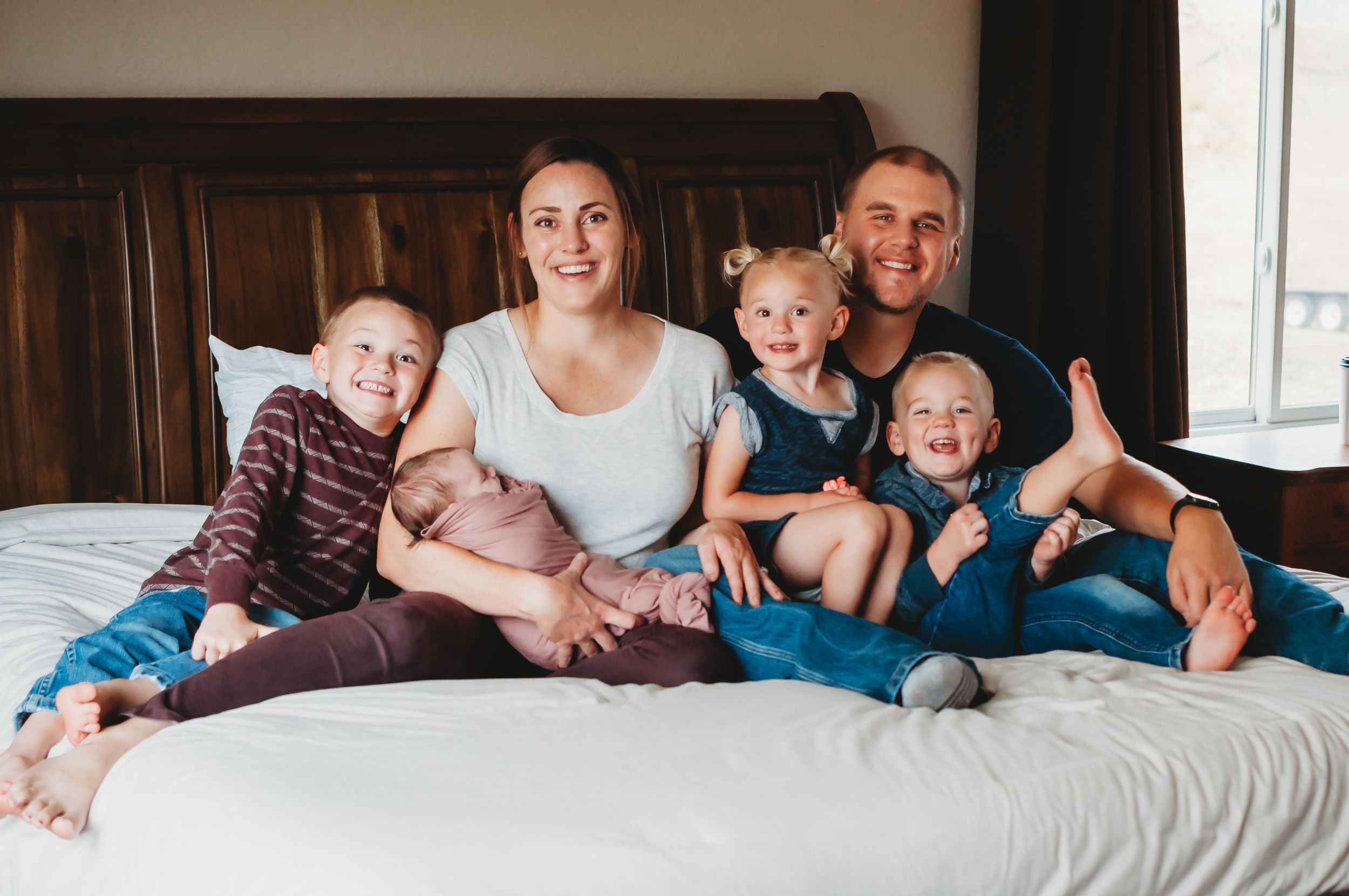 New family snuggling their baby girl during an in-home lifestyle newborn session - photographer  serving Wibaux, Montana
