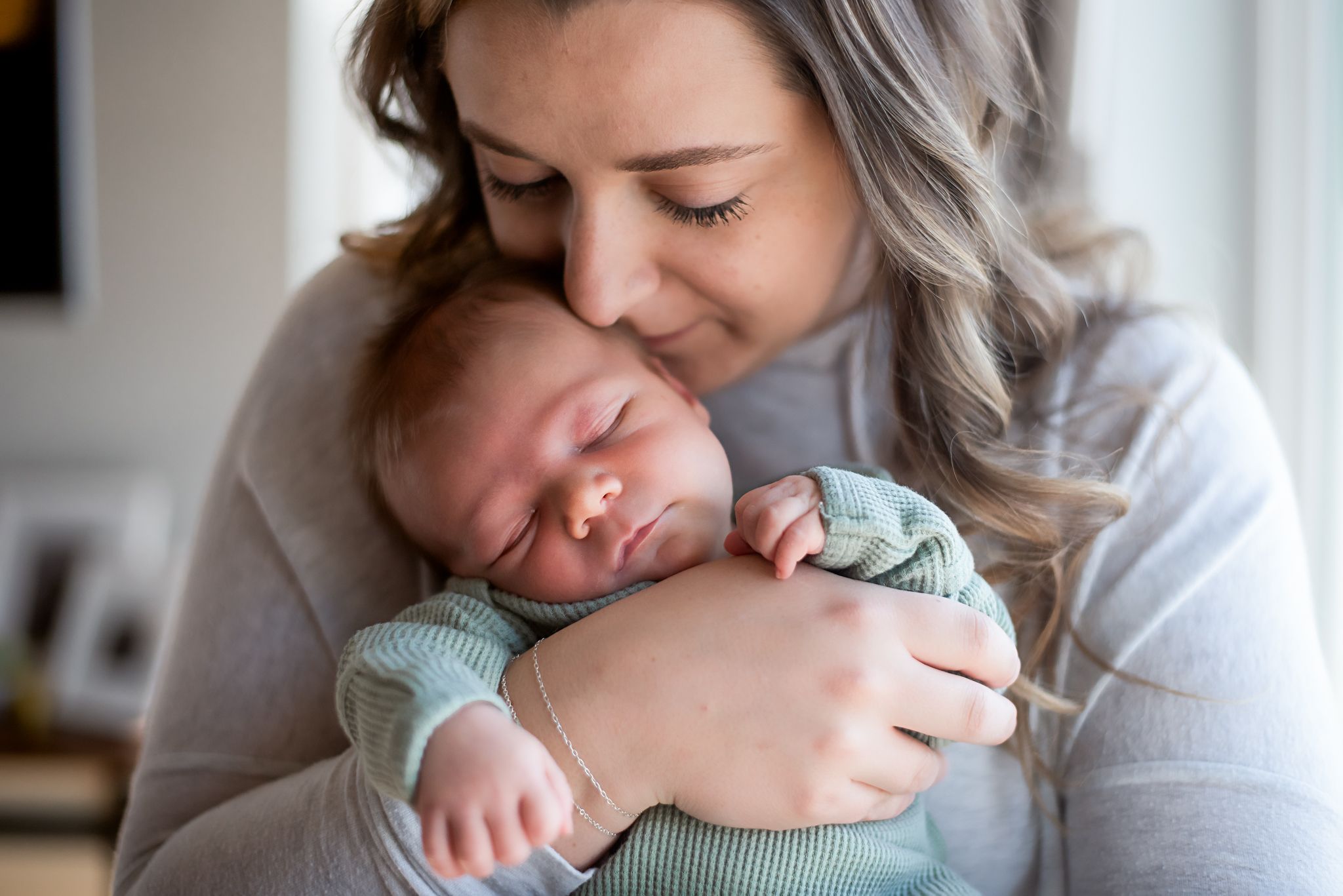 Mother holding newborn son - motherhood photography in Dickinson, ND