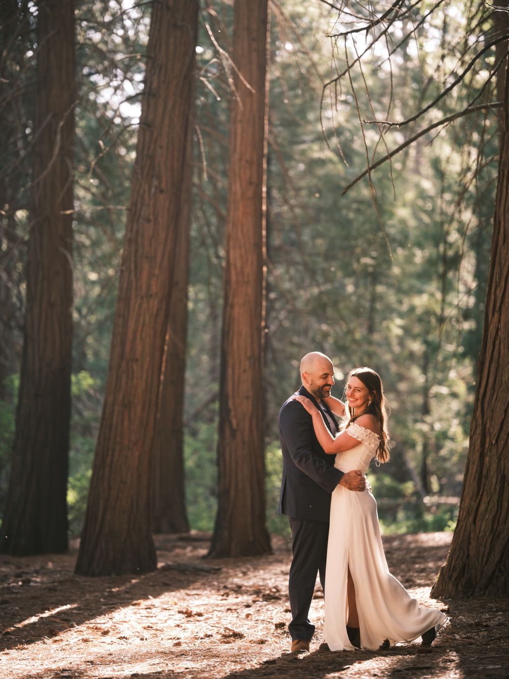 Bride and Groom standing in the middle of tall trees for Yosemite Wedding