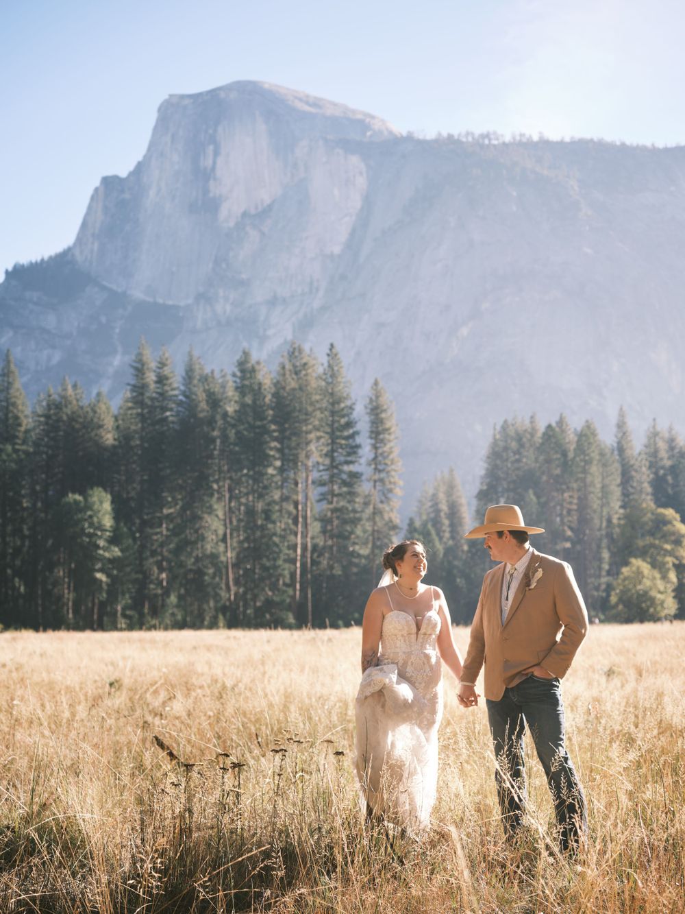 Bride and Groom walking through Yosemite Valley with Half Dome for Wedding