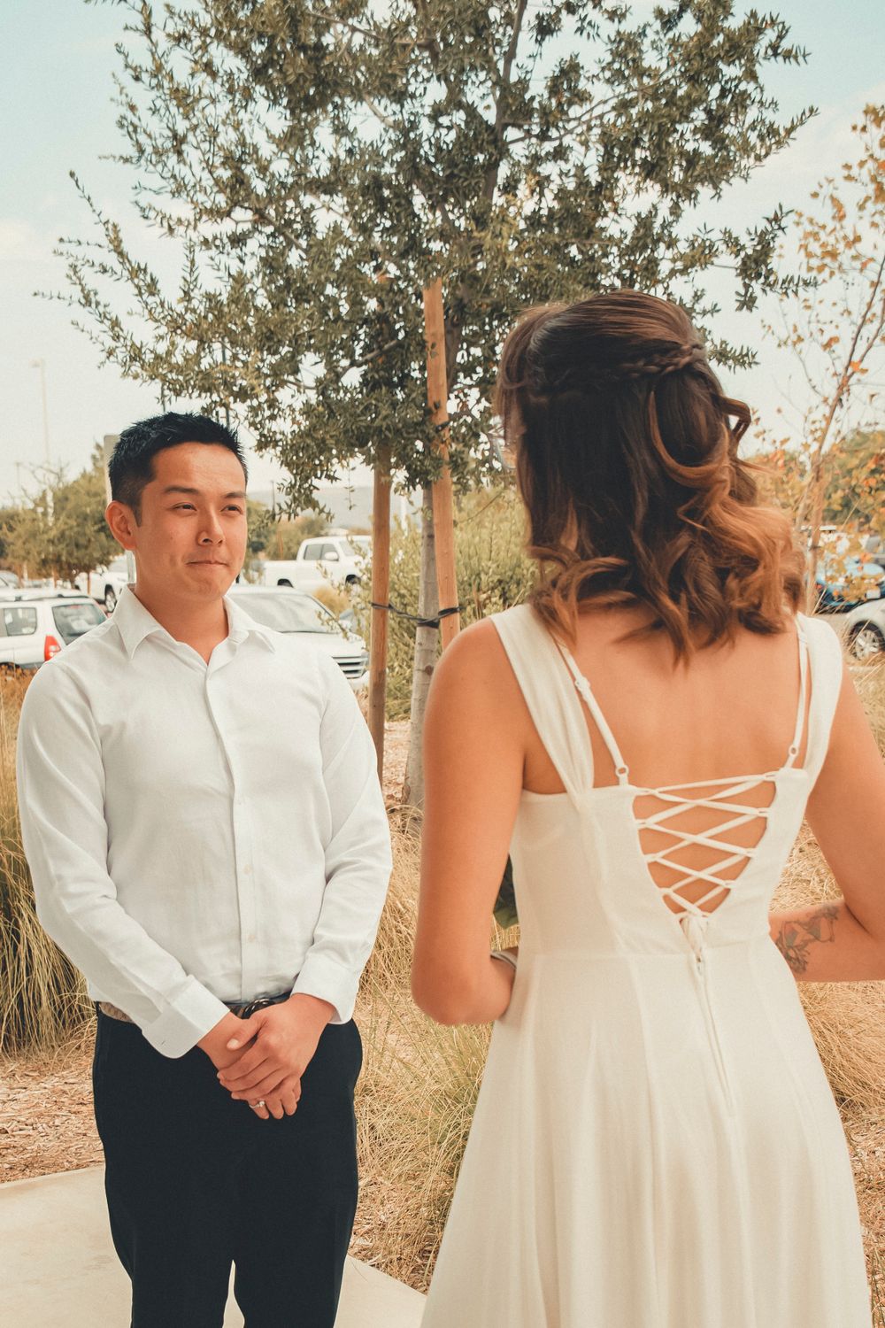 A wedding couple shares a first look moment outdoors surrounded by trees and natural scenery.