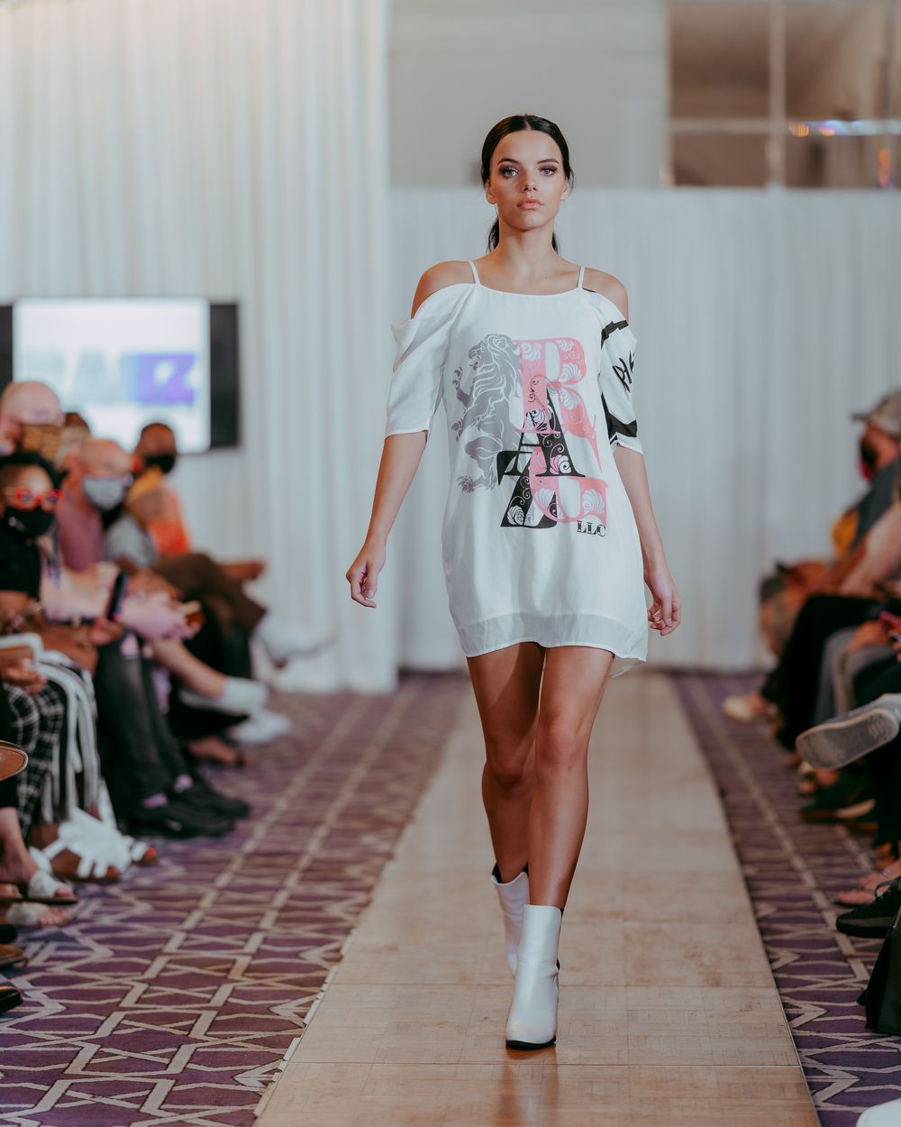 Runway show featuring oversize white t-shirt design with bold graphic print.
