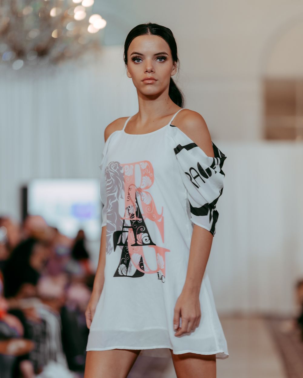 Fashion show featuring contemporary white t-shirt design with artistic elements.