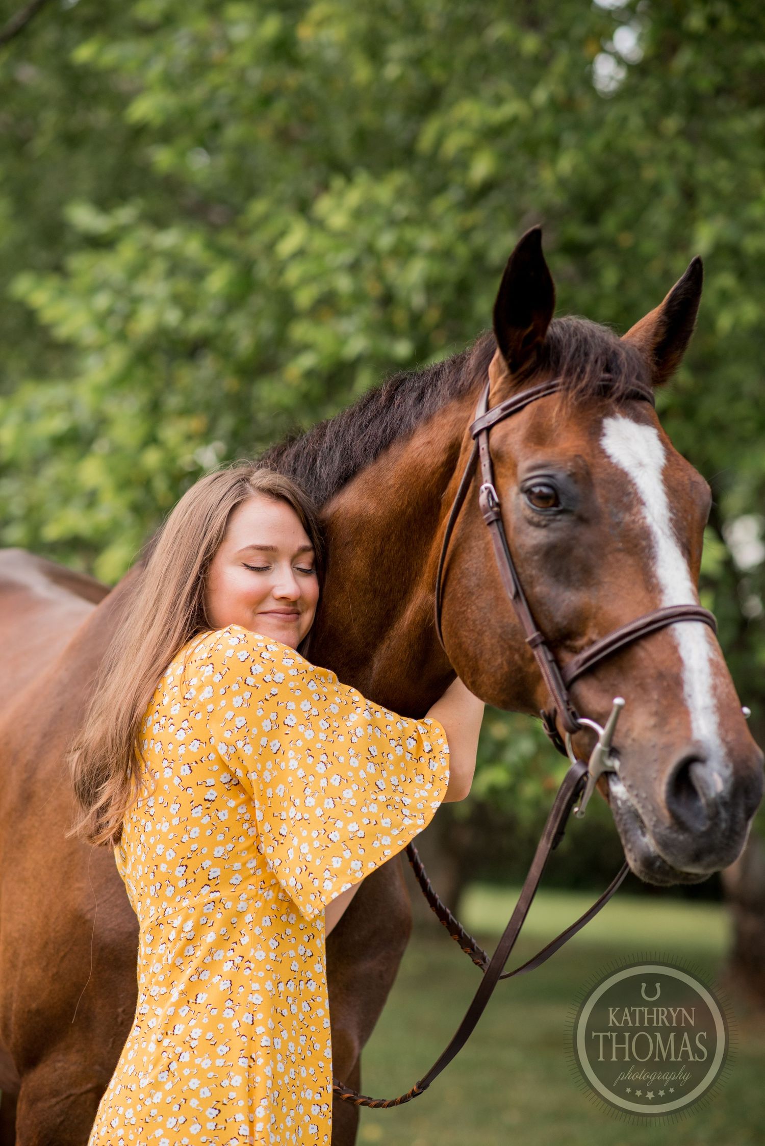 A close-up of a bay horse with white blaze and person in yellow floral dress sharing a tender moment.