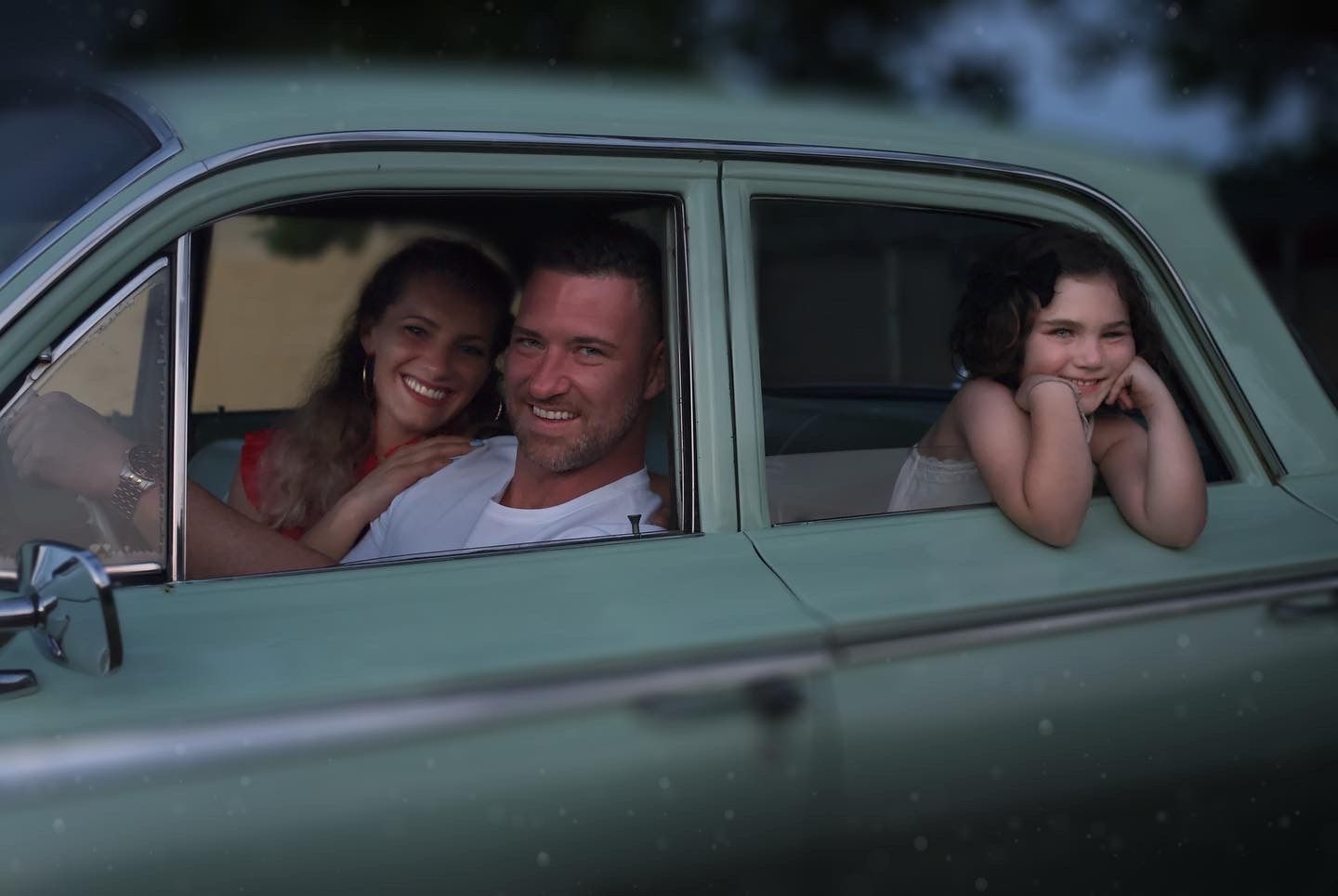 portrait of family in a classic car.