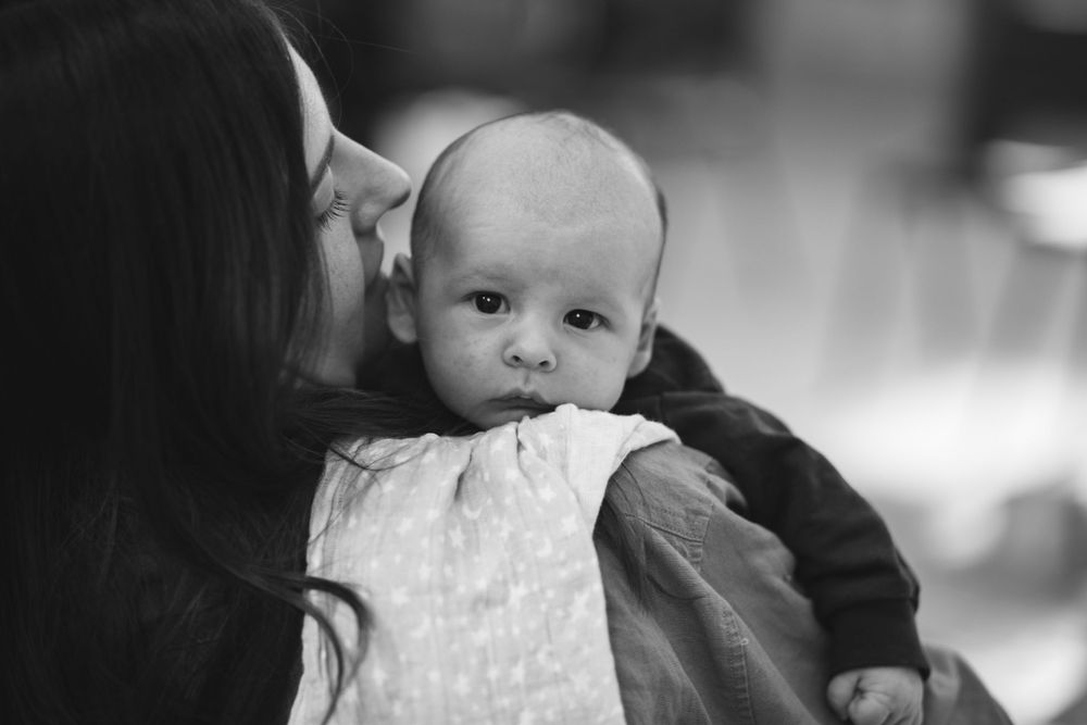 Tender black and white portrait of parent and baby in intimate moment.