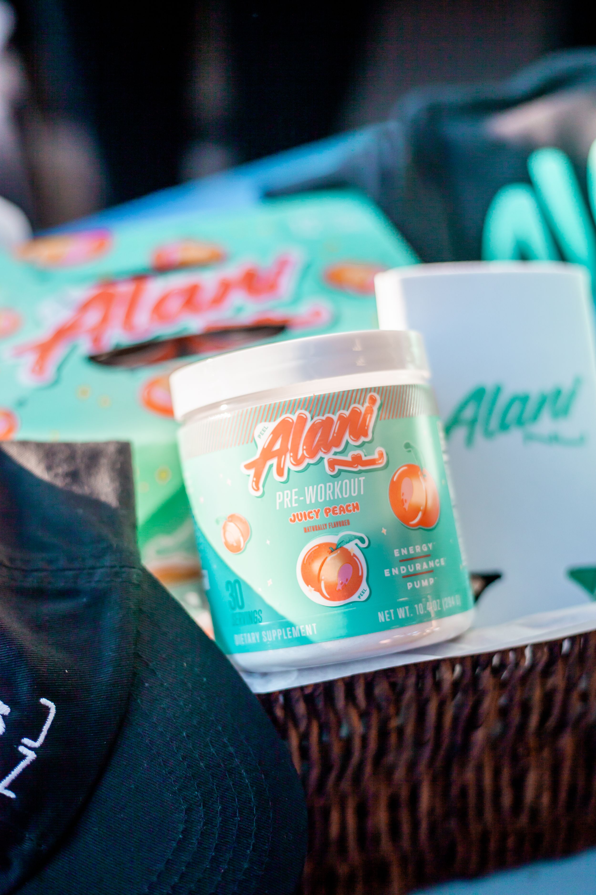 Close-up of Alani nutrition products and packaging in turquoise and peach colors.