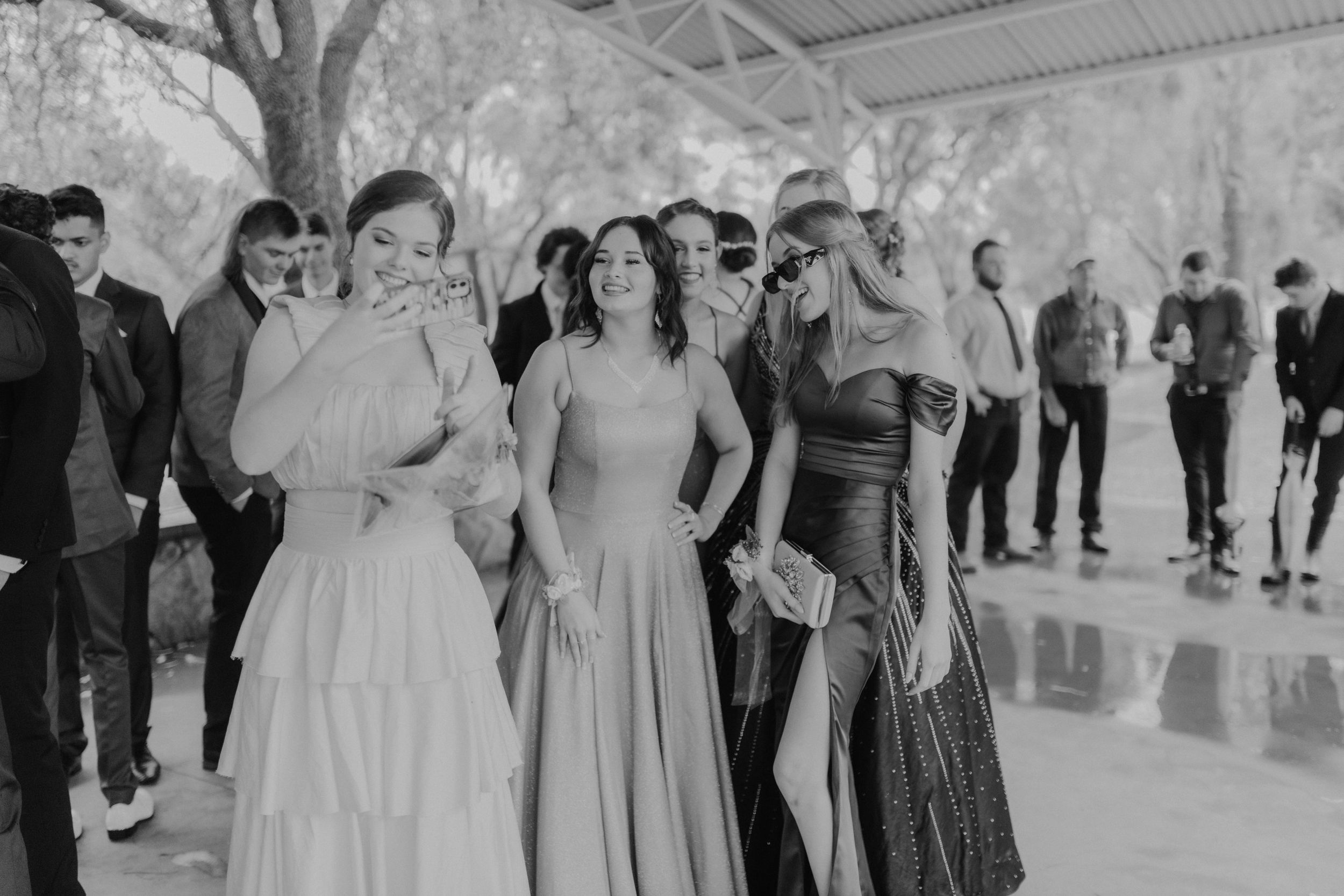 Wedding guests in formal attire gather for a black and white photo.
