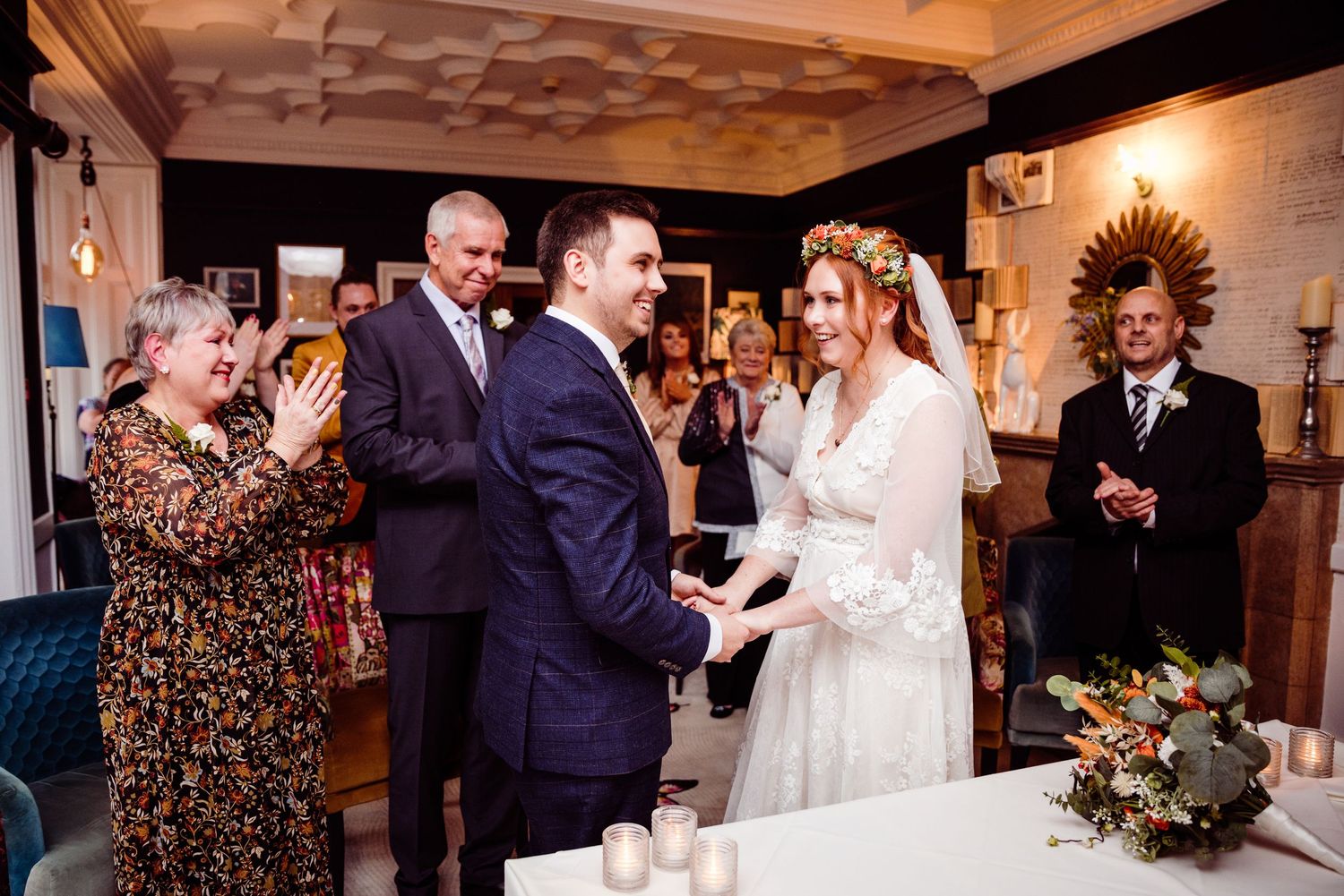 A joyful celebration during an indoor wedding ceremony with guests applauding.