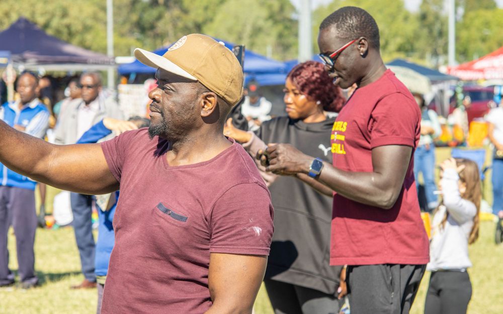 People enjoying festivities at an outdoor community event on a sunny day.
