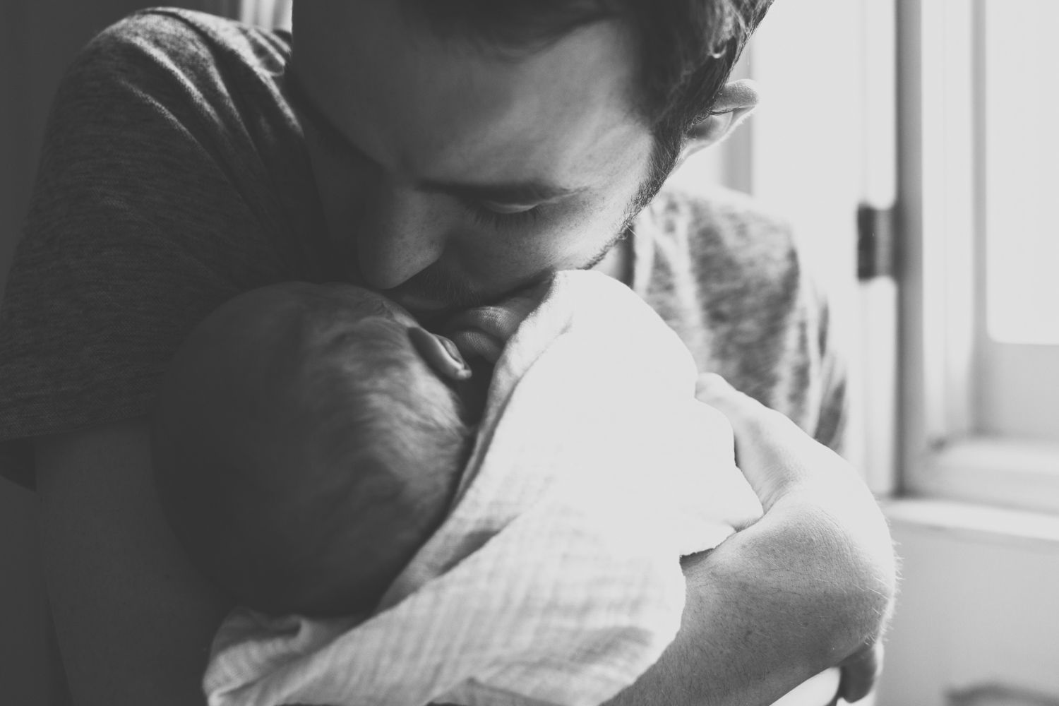 Close up of Father holding newborn baby.