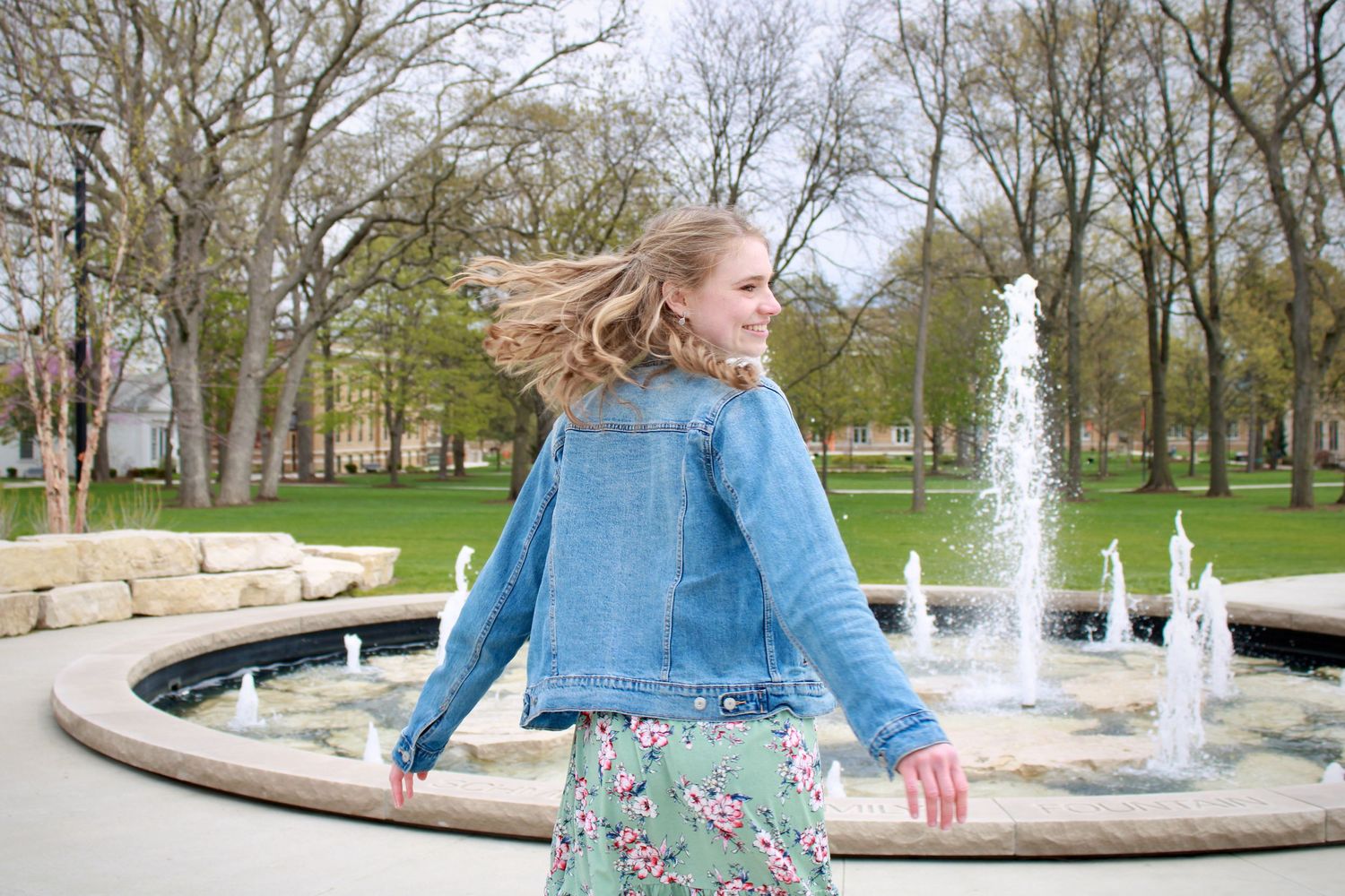 Girl in jean jacket in front of fountain