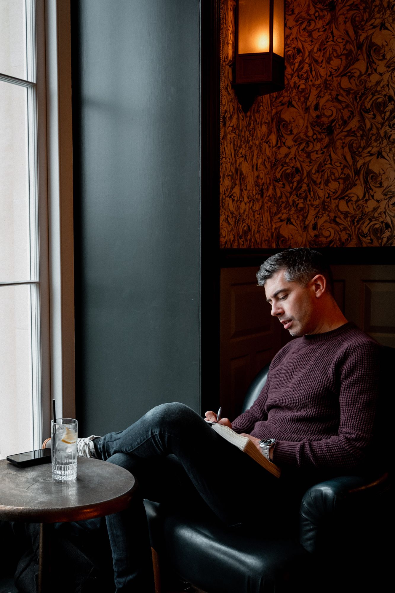 founder man sitting in hotel bar journalling