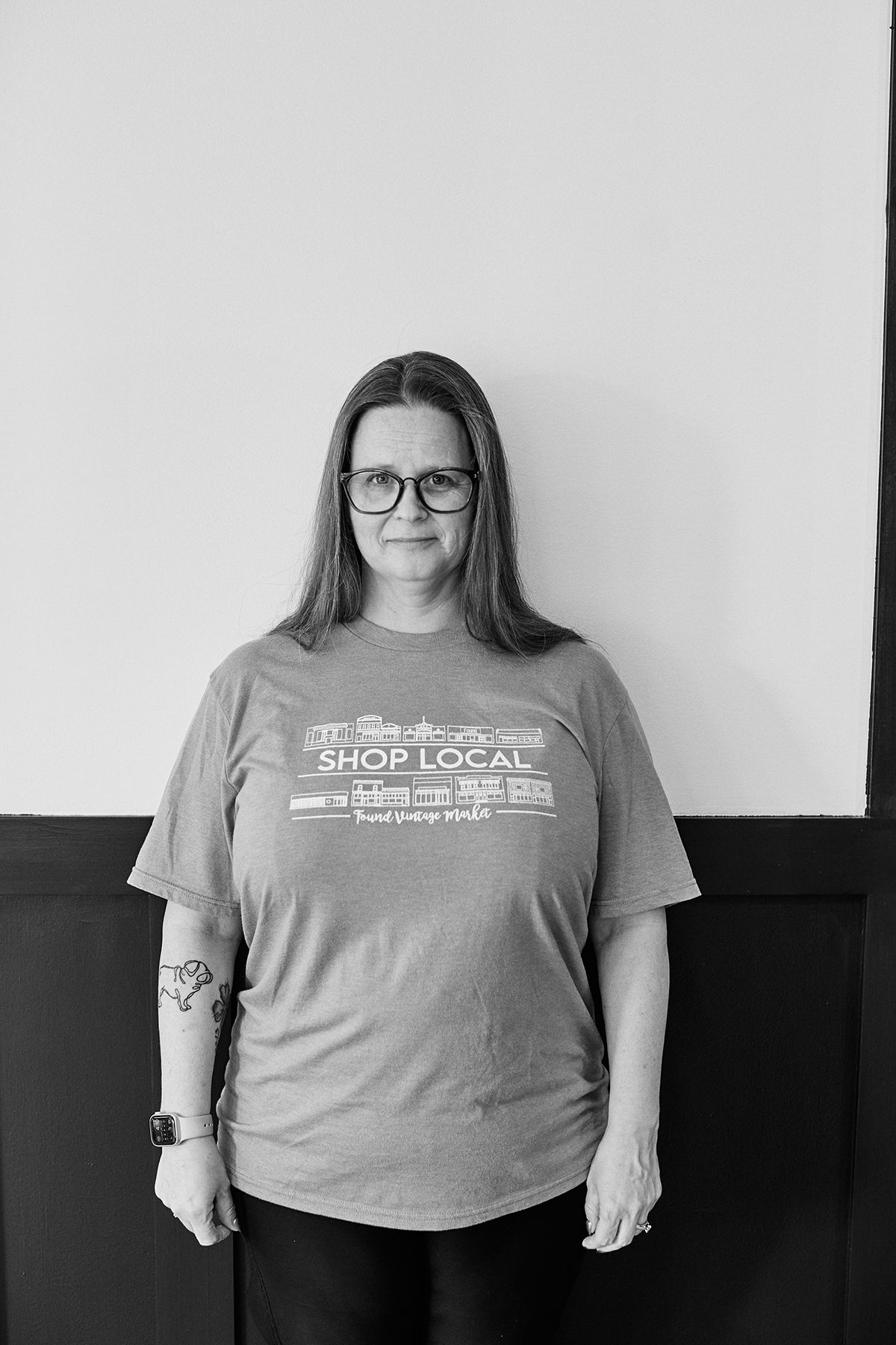 Black and white portrait showing casual pose in Shop Local t-shirt.