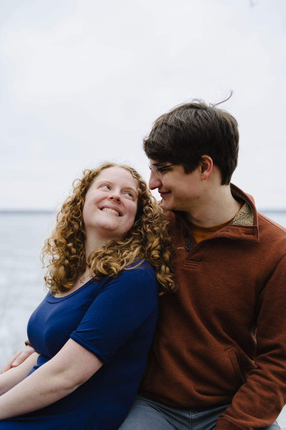 jake and emily leaning against each other with lake mendota in the background - couple photography in madison wisconsin