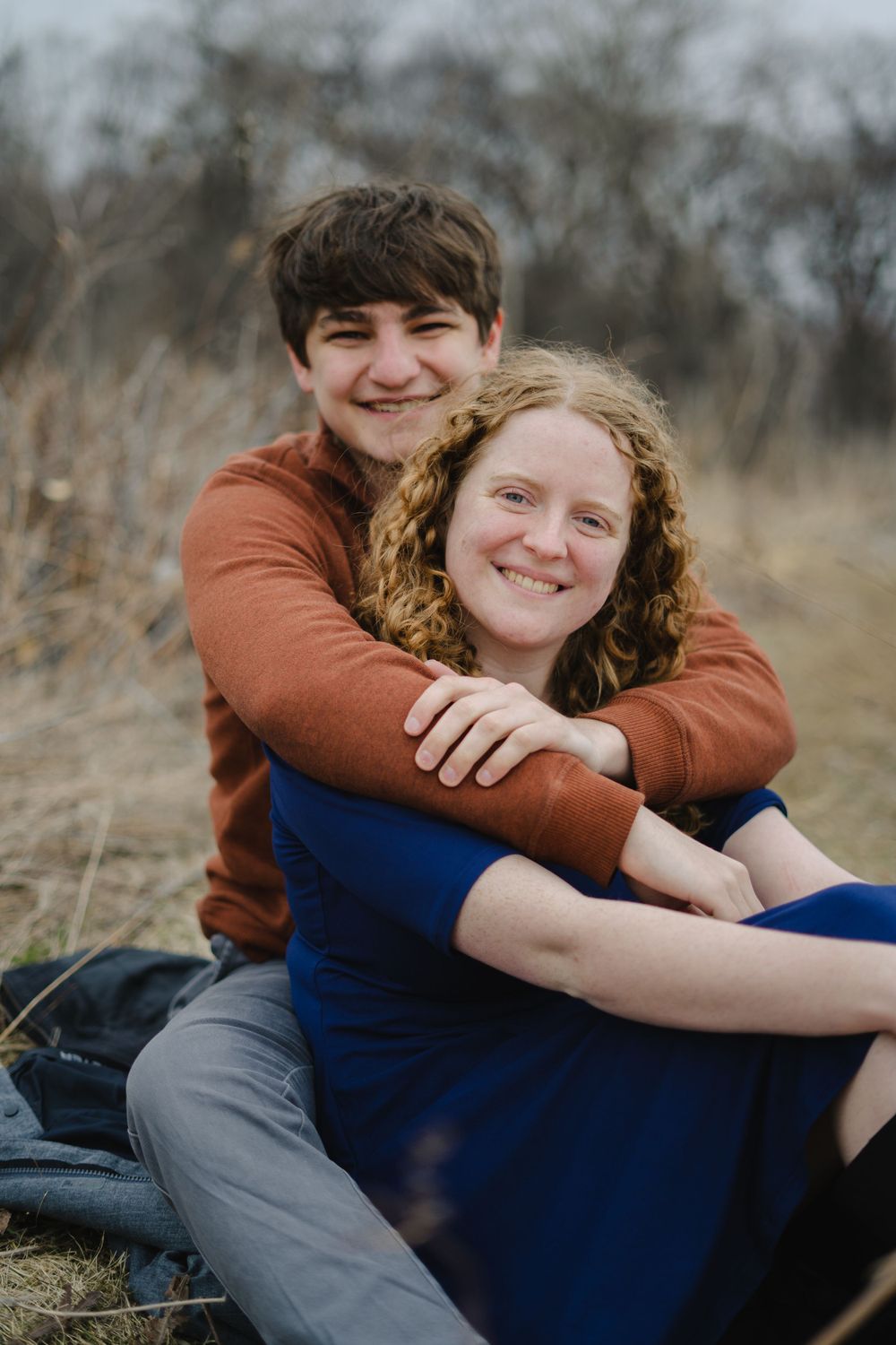 jake hugging emily from behind and smiling - couple photography in madison wisconsin