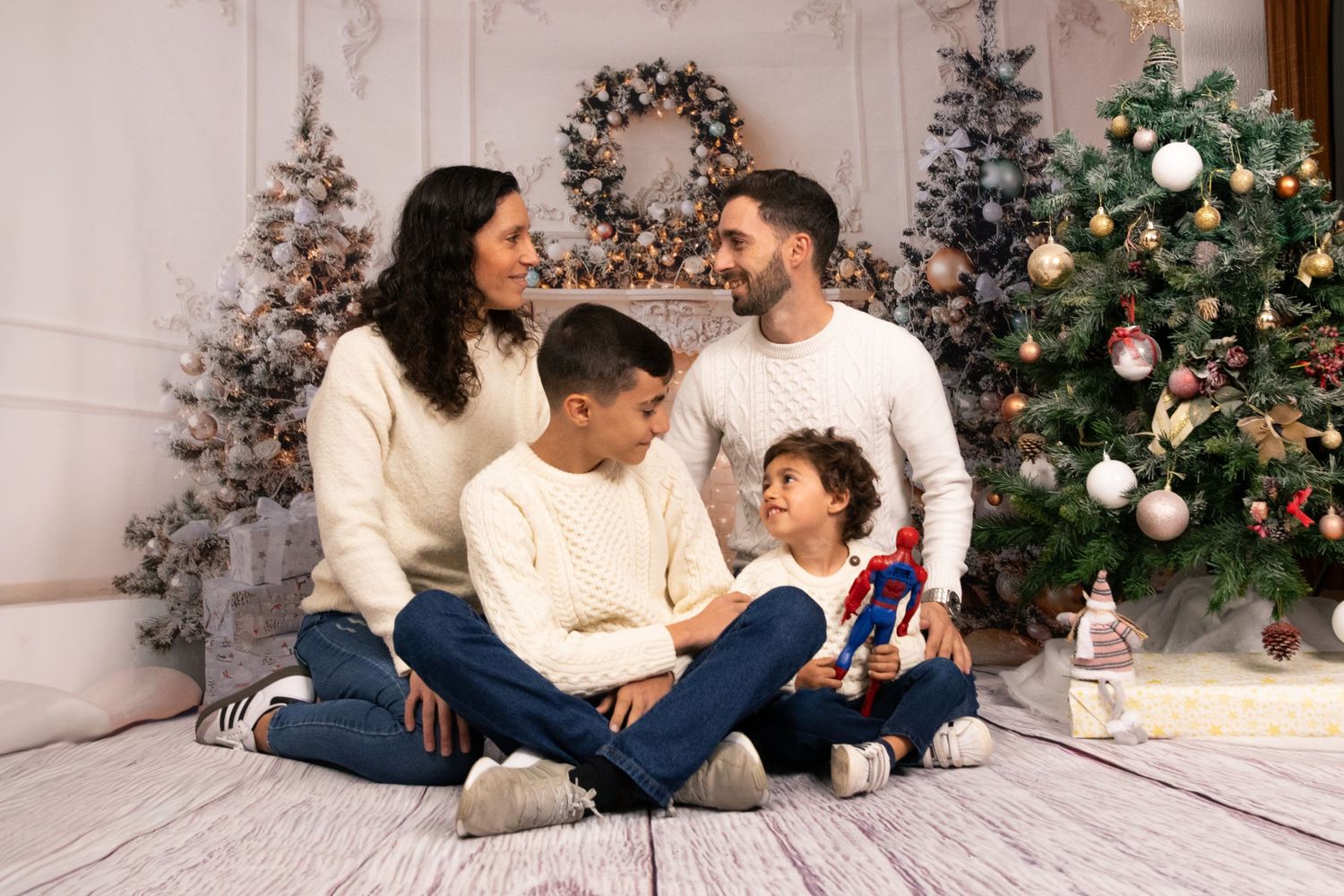 Family Christmas photo session with decorated tree in background.