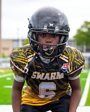 Football player in black and yellow Swarm uniform with number 6 on game field.
