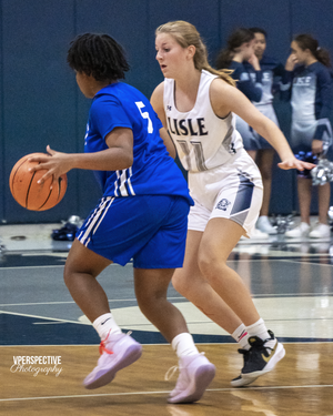 Basketball players from opposing teams compete for ball possession during indoor game.