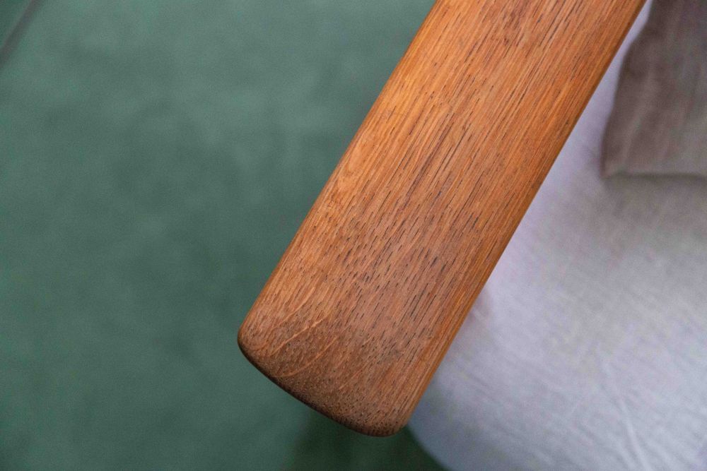 Close-up detail of wooden furniture leg on polished mint green concrete flooring.