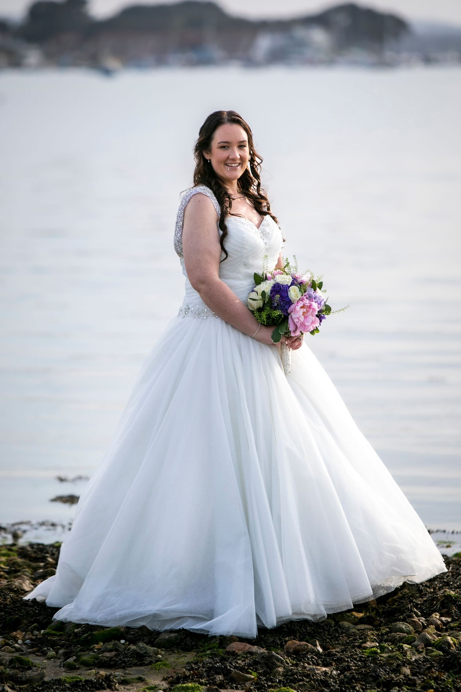 Beautiful white ballgown wedding dress photographed against a coastal backdrop.