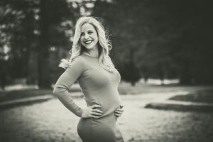 Striking a gorgeous pose, this vintage picture shows a woman cradling her small pregnant belly