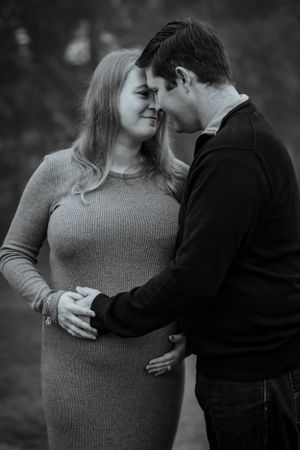 A husband excitedly awaits the arrival of his baby and lovely kisses his wife