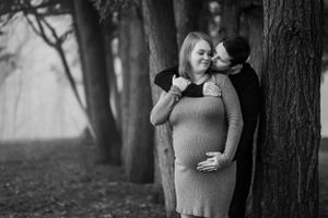 A husband excitedly awaits the arrival of his baby and lovely kisses his wife