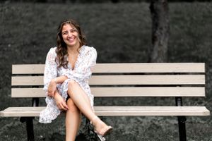 stunning colors in a captivating senior portrait of a vibrant young girl lazily resting on a bench