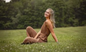 a girl lets the rain fall around her as she lifts her head to the sky and takes it in